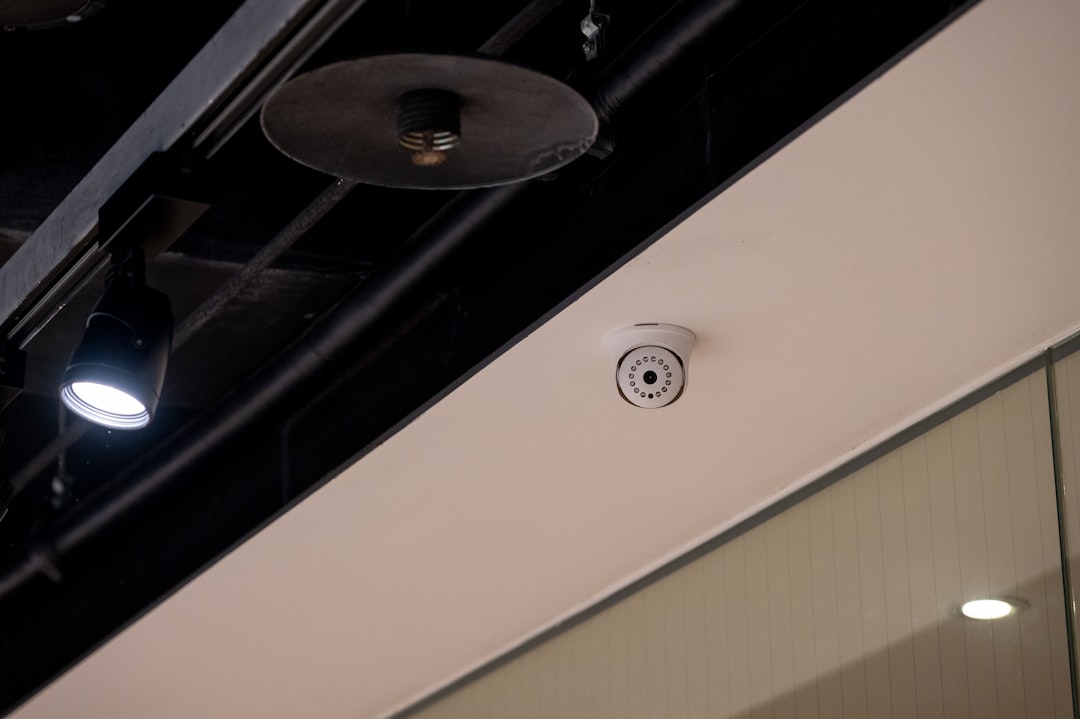 Security camera mounted on a white ceiling.